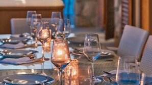 A dining table set with wine glasses, plates, and cutlery, with a candle in the center. - Villa Amfora- Six Bedroom Villa with Terrace and Swimming Pool, 2X Jacuzzi and Sea View (Prižba)