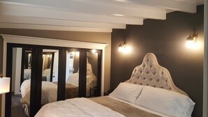 A bedroom with a large bed, a mirror, and two wall-mounted lights. - Private Cottage Oasis in CdM - Ideal Village Location on XL Lot (Corona del Mar)
