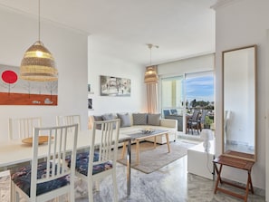 A modern living room with a sofa, dining table, chairs, and artwork on the walls. - Lorcrisur by Interhome (Marbella)