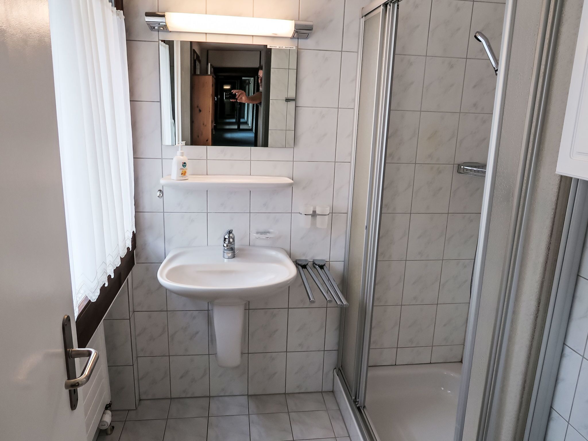 Ein Badezimmer mit Waschbecken, Spiegel und Dusche.