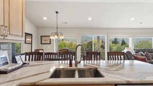 Una cocina moderna con una isla grande, armarios de madera y lavavajillas.