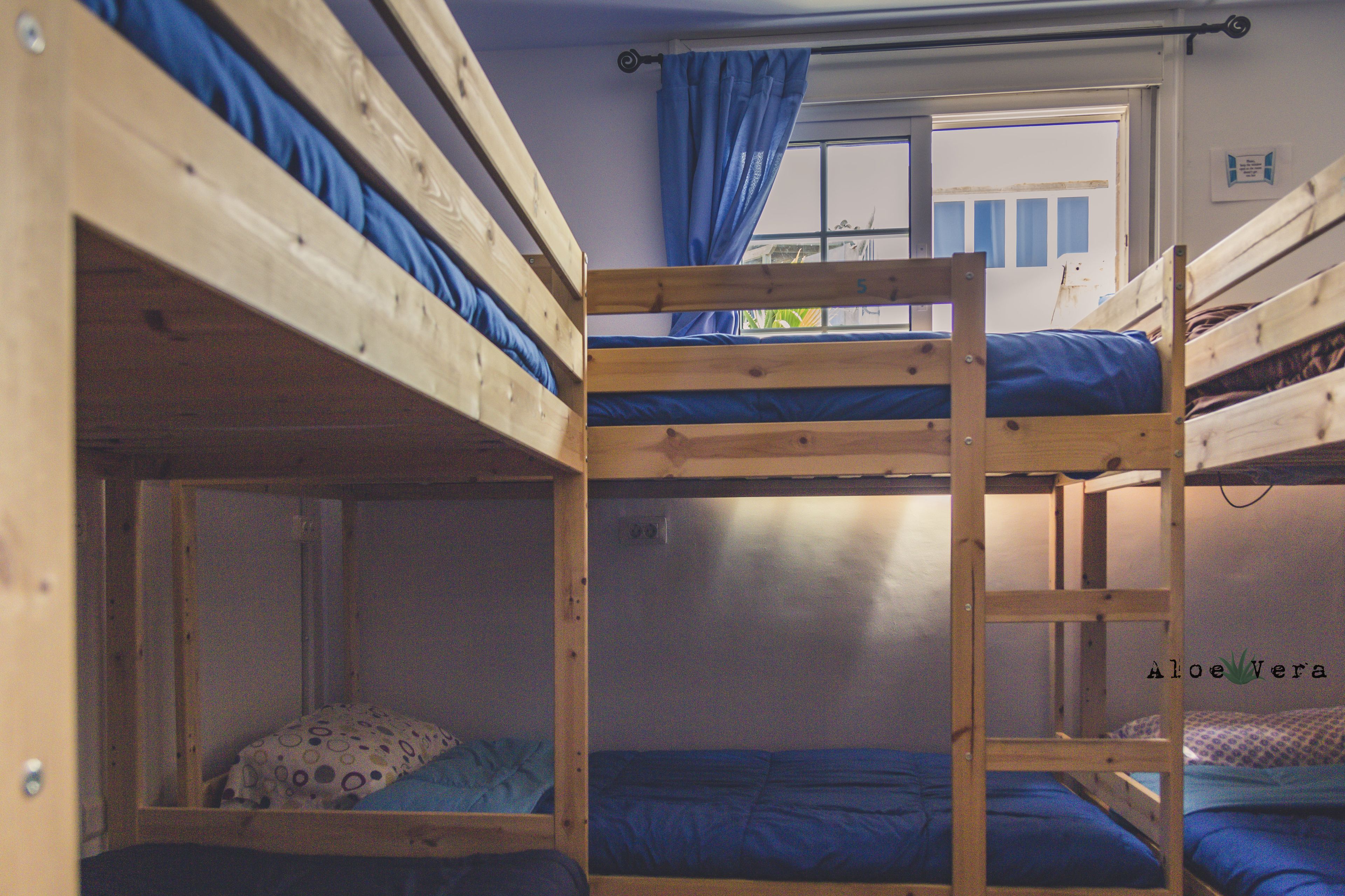 A bunk bed room with a window and curtains.