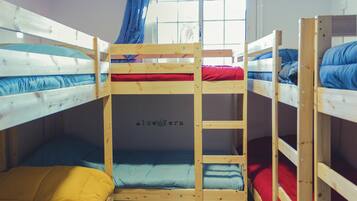 A bunk bed room with three levels, each with a different colored mattress.