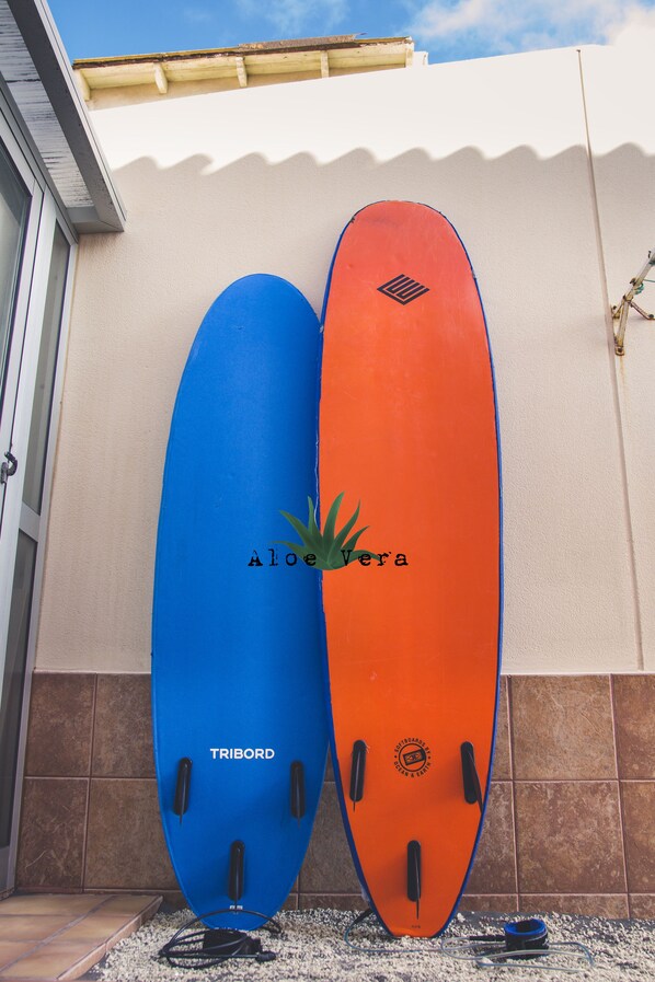 Deux planches de surf appuyées contre un mur.