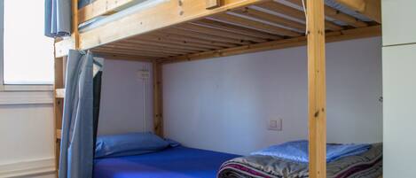 A bunk bed with a blue mattress and a blanket.