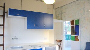 Una cocina compacta con armarios azules, una encimera blanca y un lavamanos pequeño.