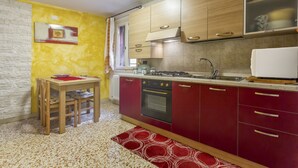 Una cucina compatta con mobili in legno, forno integrato e microonde.