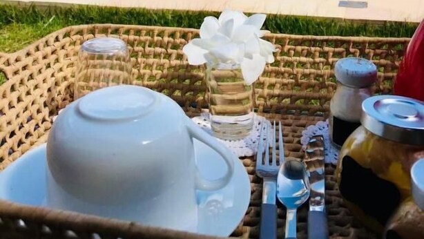 A poolside dining setup with a table, a teapot, and a flower vase. - Villa Isola Bella (Fortim)