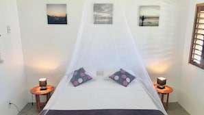 A bed with a canopy, two bedside tables, and three wall-mounted pictures. - Villa Isola Bella (Fortim)