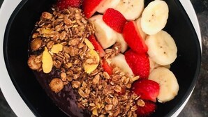 A bowl of granola with strawberries and banana slices. - Villa Isola Bella (Fortim)