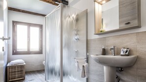 Une salle de bain moderne avec une douche à parois de verre, un lavabo et un miroir.