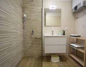 Apartamento, planta baja (B1) | Baño | Ducha, secador de pelo, toallas y jabón
