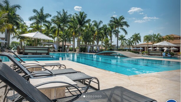 A pool area with lounge chairs, umbrellas, and palm trees. - House with heated pool. Santa Bárbara Resort Residence #casadecampo131 (Águas de Santa Bárbara)
