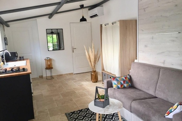 Espace de vie, salon, lit escamotable: un vrai lit mais un gain de place.