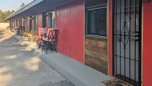Eine Reihe von Zimmern mit roter Fassade, Holztürrahmen und einem verschlossenen Eingang.