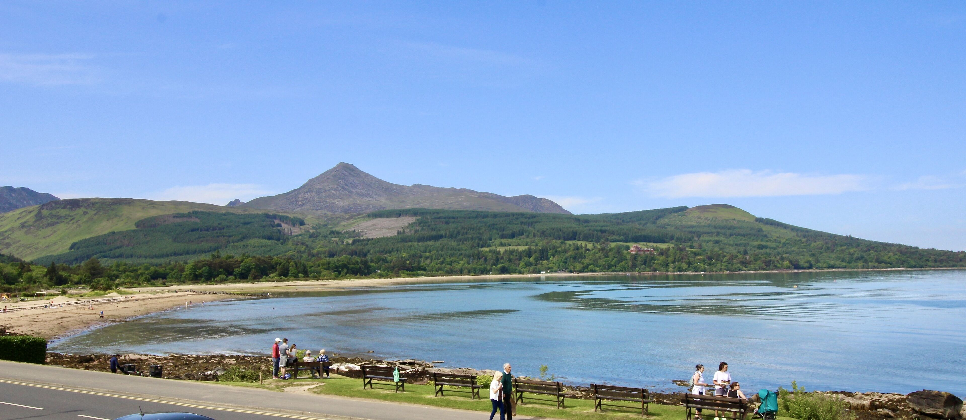 A coastal road with a view of a lake and mountains.