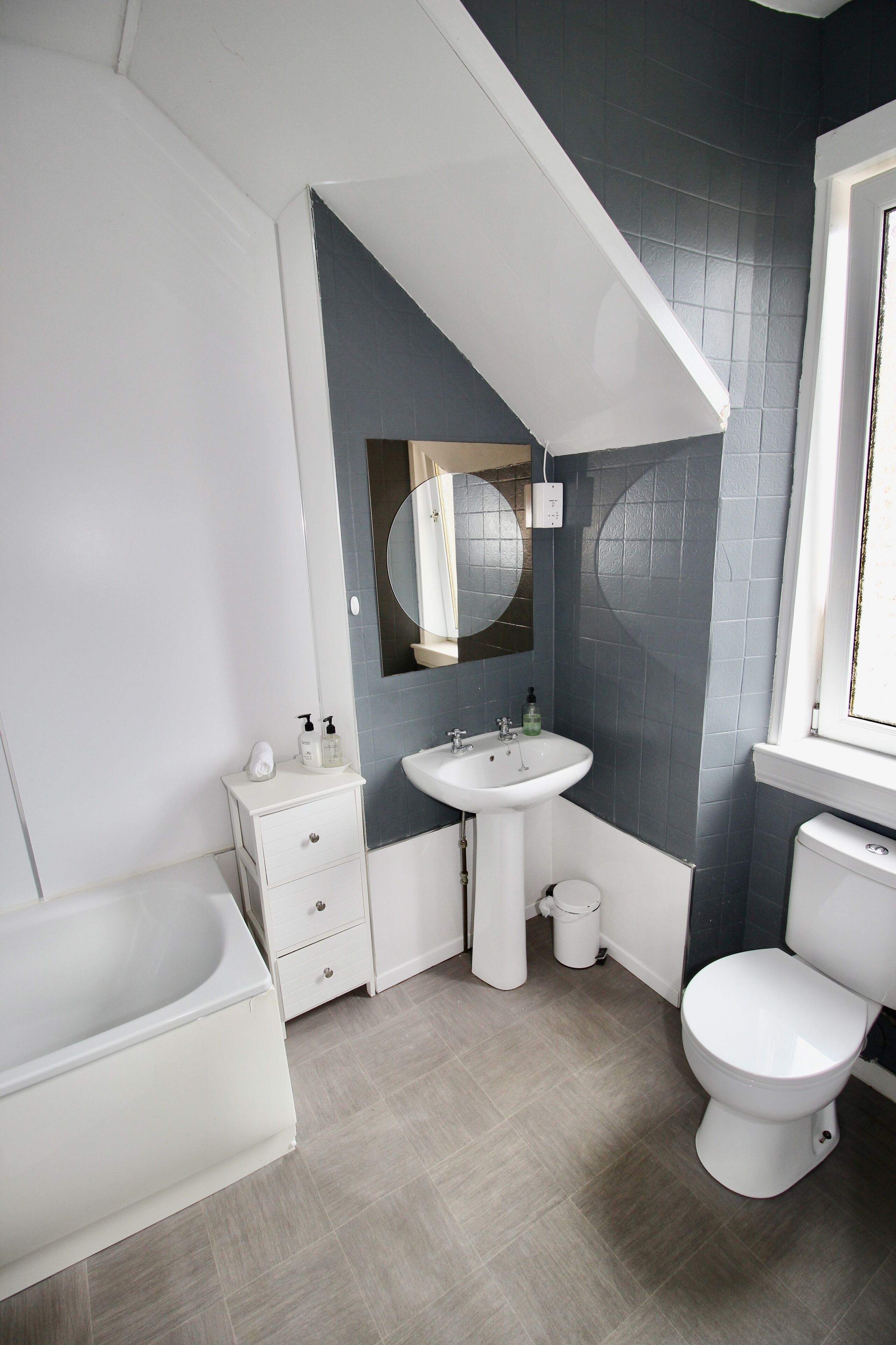 A modern bathroom with a bathtub, a sink, and a toilet.