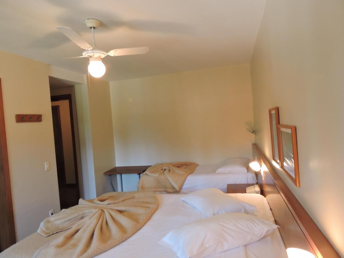 Una habitación de hotel con una cama, un ventilador de techo y una luz nocturna.
