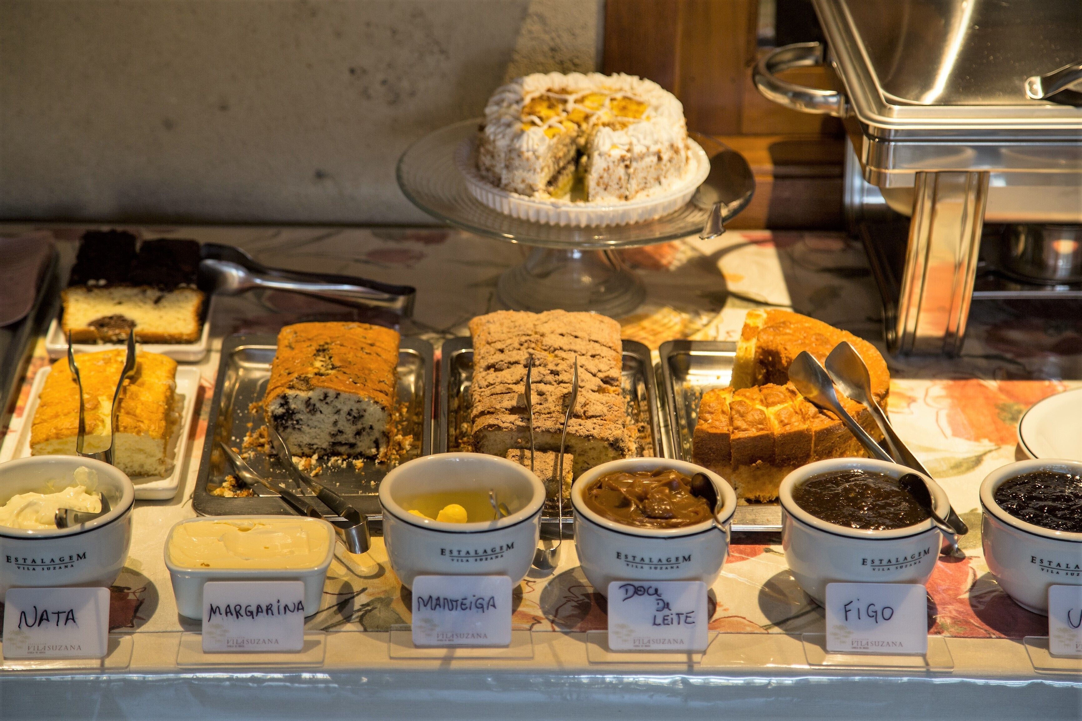 A display of various desserts and dips, including cakes and sauces, with labels indicating names and types.