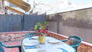 A round table with chairs, a vase with flowers, and a bottle of water. - Fleming by Interhome (Lloret de Mar)