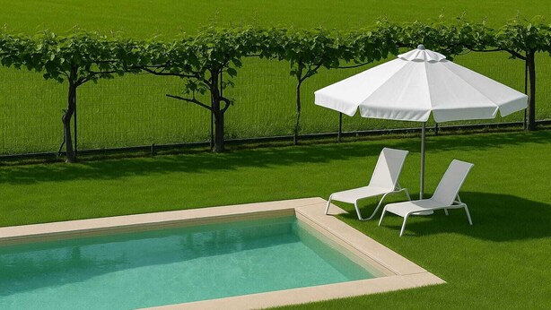 Una piscina amb dues gandules blanques i un parasol blanc.