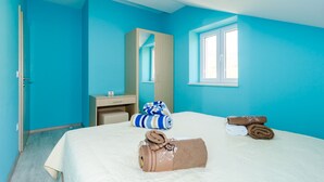 Una habitación de hotel con una cama, un escritorio, un espejo y una ventana.