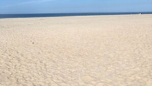 Ein Strand mit blauem Himmel und ruhiger See.