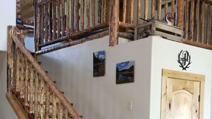 A wooden staircase with a rustic design, a wooden door, and a small rug on the floor.