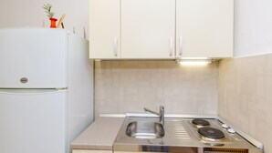 Een keuken met een witte koelkast, een roestvrijstalen spoelbak en een dubbele oven.