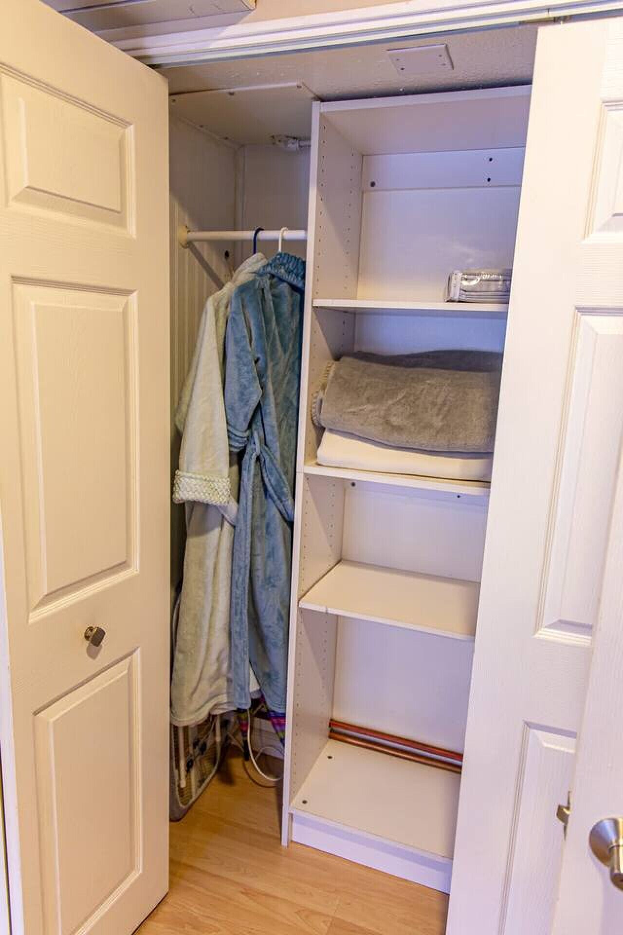 A walk-in closet with open doors, shelves, and hanging space.