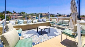 Une terrasse sur le toit, avec des sièges, une table et des parasols.