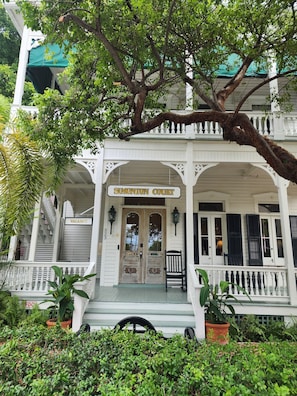 A white building with a porch, a sign reading 'Simonton Court,' and a 'Vacancy' sign. - Simonton Court Historic Inn & Cottages (Key West)