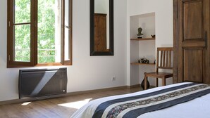 A bedroom with a bed, a window, a mirror, a radiator, a chair, and a wooden cabinet. - Suite Luna, design & spa, just for couple (Carnas)