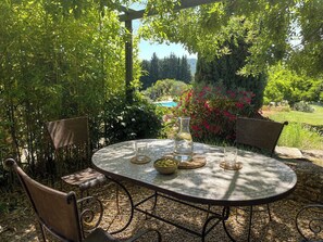 A round table with chairs, a glass pitcher, and a bowl of olives.