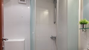 Ein Badezimmer mit Duschkabine, Toilette und Waschbecken.