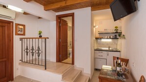 Eine moderne Küche mit Backofen, ein Essbereich mit Glastisch und eine Treppe mit dekorativer Geländer.