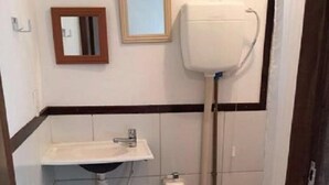 Un bany petit amb vàter, rentapel i mirall.