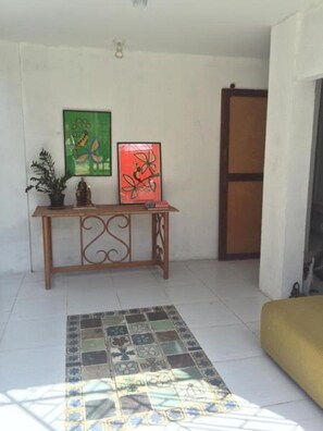 Relax in a stylish space with a geometric-patterned floor, console table, and artwork-adorned walls.