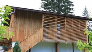 Un bâtiment en bois doté d’un toit en pente et d’un escalier en bois.
