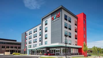 Experience the Avid Anning Hotel's sleek, modern design with large windows and inviting outdoor spaces.