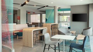 A modern lounge area with seating, a counter, and a TV screen. - avid hotels Madison - Monona by IHG (Madison)