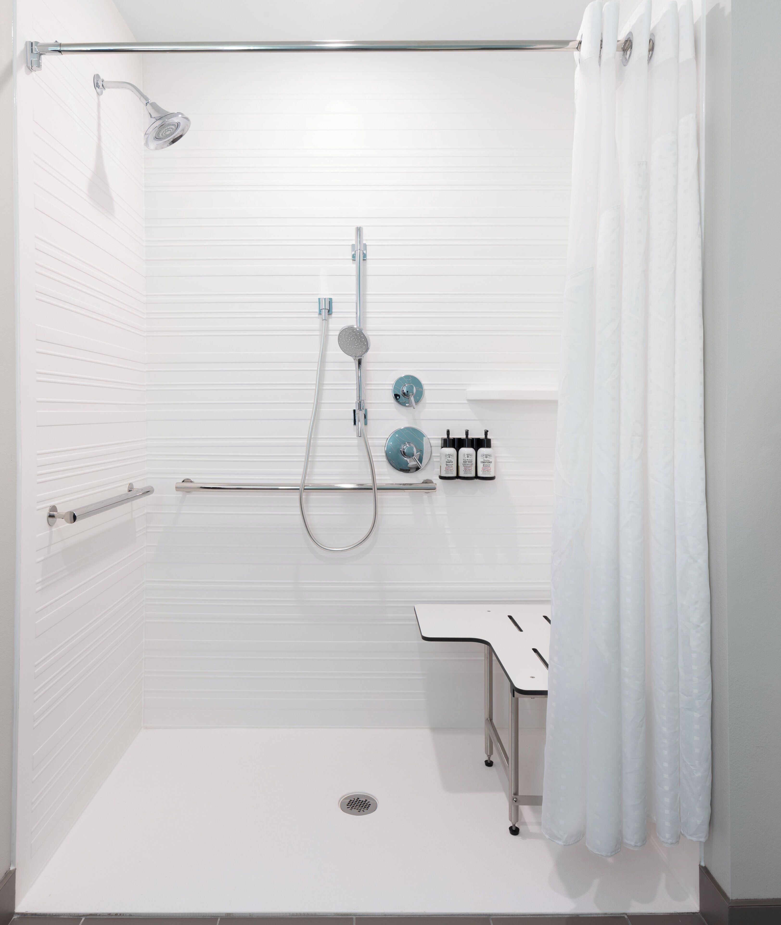 A modern bathroom with a shower, a sink, and a toilet.
