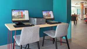A modern office space with two desktop computers, a printer, and two grey chairs. - avid hotels Madison - Monona by IHG (Madison)