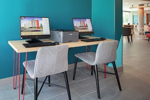 A modern office space with two desktop computers, a printer, and two grey chairs. - avid hotels Madison - Monona by IHG (Madison)