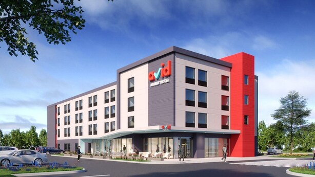 A modern hotel with a prominent red and grey facade, multiple floors, and a covered entrance area. - avid hotels Beaumont by IHG (Beaumont)