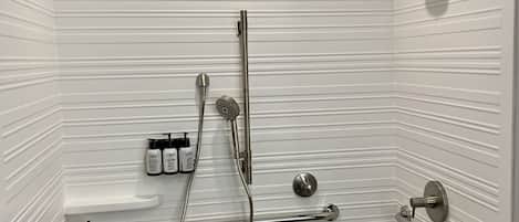 A modern bathroom with white tiled walls, a shower with a handheld showerhead, a handheld showerhead, a handheld showerhead, a handheld showerhead, a handheld showerhead, a handheld showerhead, a handheld showerhead, a handheld showerhead, a handheld showerhead, a handheld showerhead, a handheld showerhead, a handheld showerhead, a handheld showerhead, a handheld showerhead, a handheld showerhead, a handheld showerhead, a handheld showerhead, a handheld showerhead, a handheld showerhead, a handheld showerhead, a handheld showerhead, a handheld showerhead, a handheld showerhead, a handheld showerhead, a handheld showerhead, a handheld showerhead, a handheld showerhead, a handheld showerhead, a handheld showerhead, a handheld showerhead, a handheld showerhead, a handheld showerhead, a handheld showerhead, a handheld showerhead, a handheld showerhead, a handheld showerhead, a handheld showerhead, a
