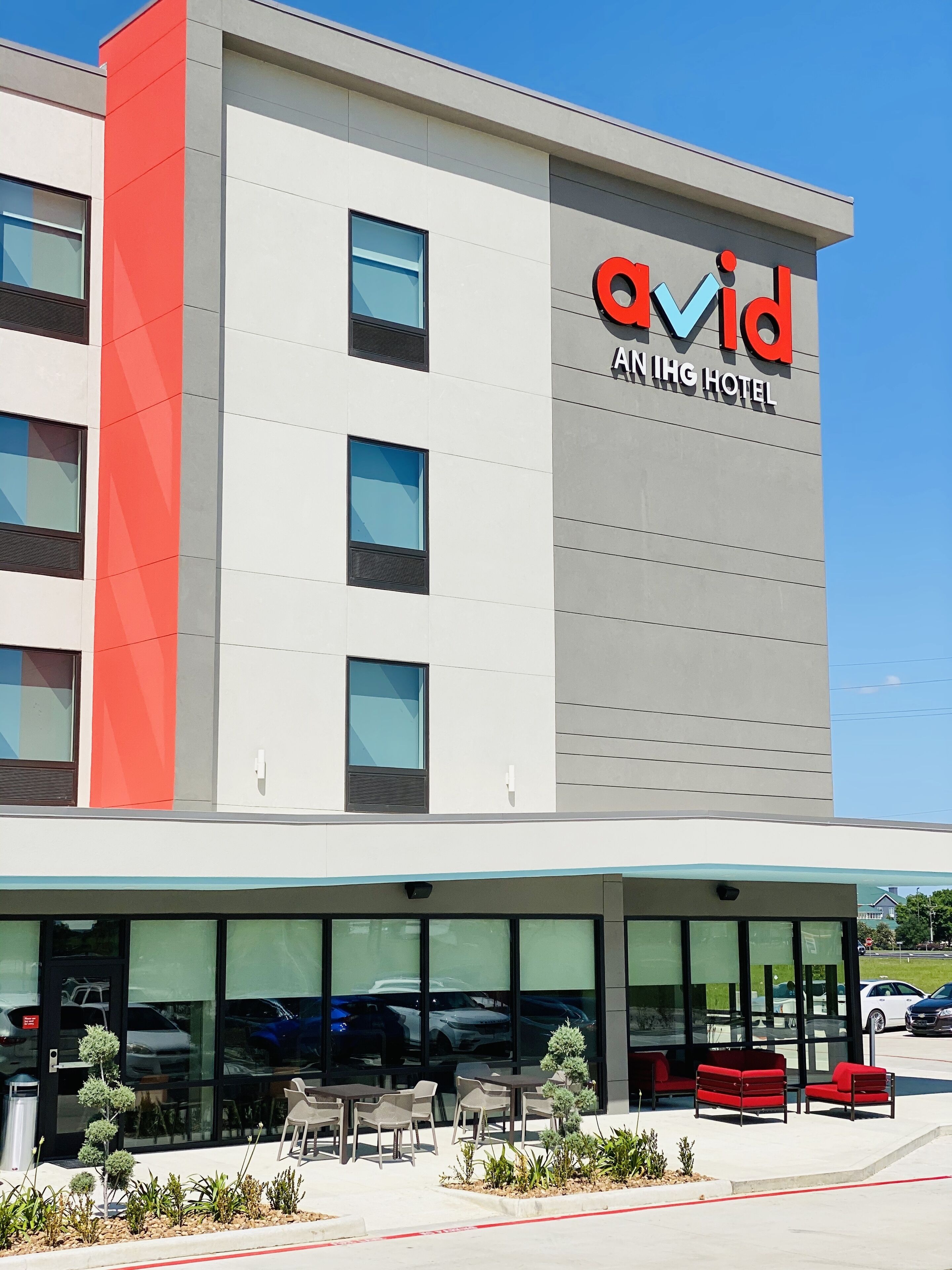 Un edificio moderno con un letrero que dice 'Avid An IHG Hotel'.