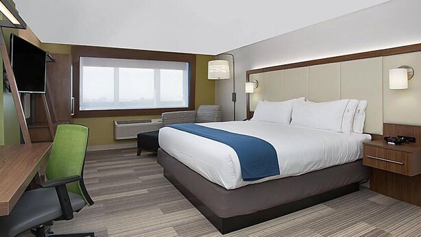 A hotel room with a large bed, a desk with a chair, a TV, and a window with a view. - Holiday Inn Express & Suites Romeoville - Joliet North by IHG (Romeoville)