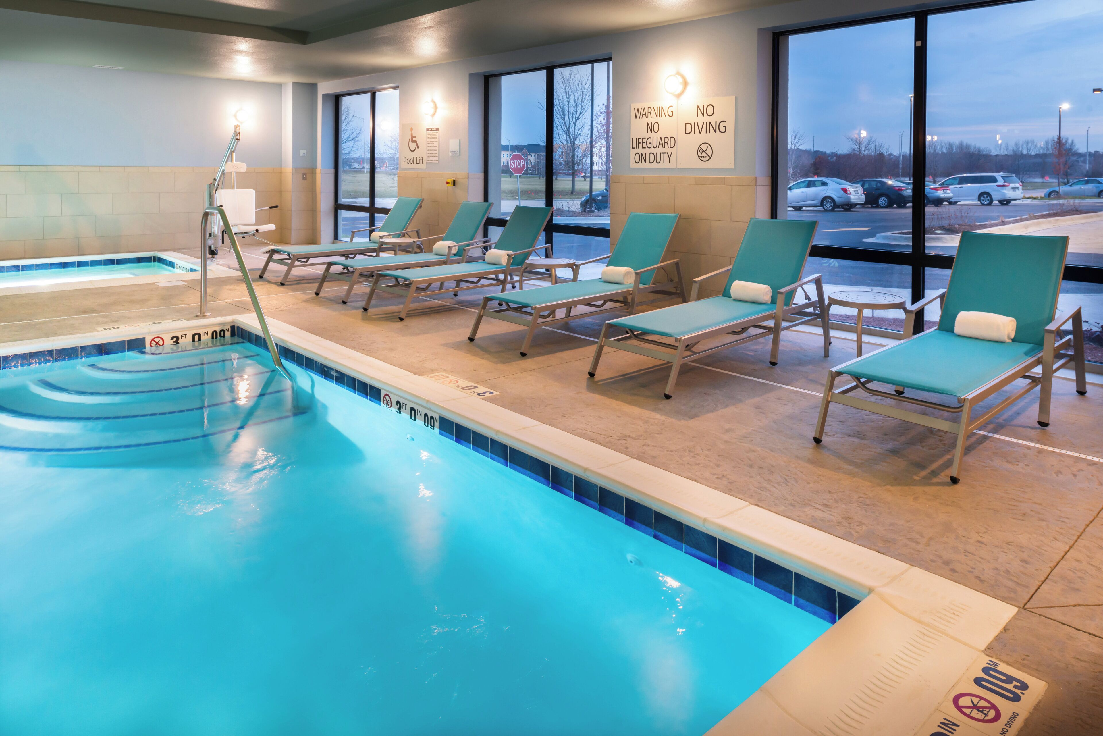 A swimming pool area with lounge chairs and a pool lift.