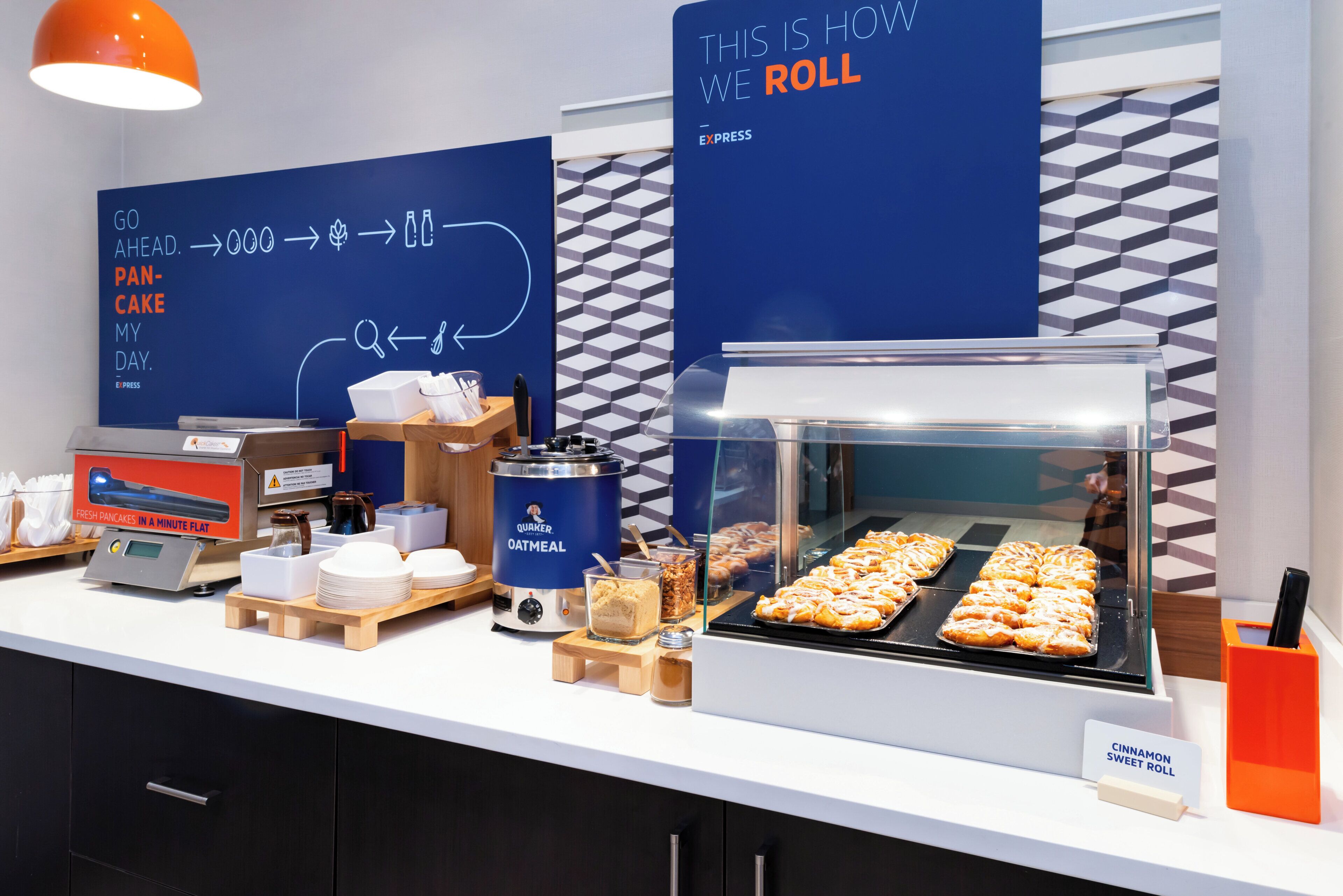 Ein reichhaltiges Frühstücksbuffet mit verschiedenen Speisen, darunter Pfannkuchen, Haferbrei und Brötchen.